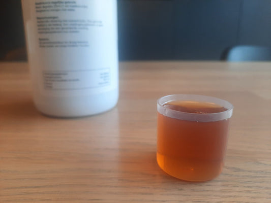 maatbekertje vloeibaar viscollageen op een houten tafel