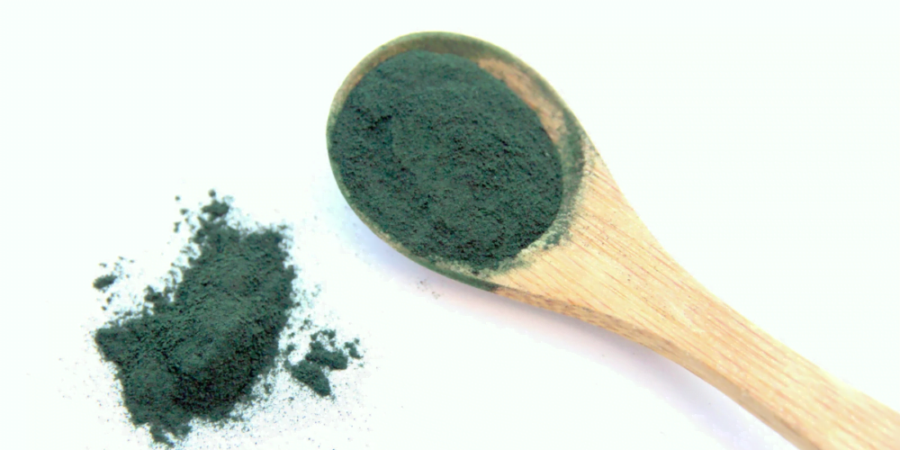groene spirulina op een houten lepel